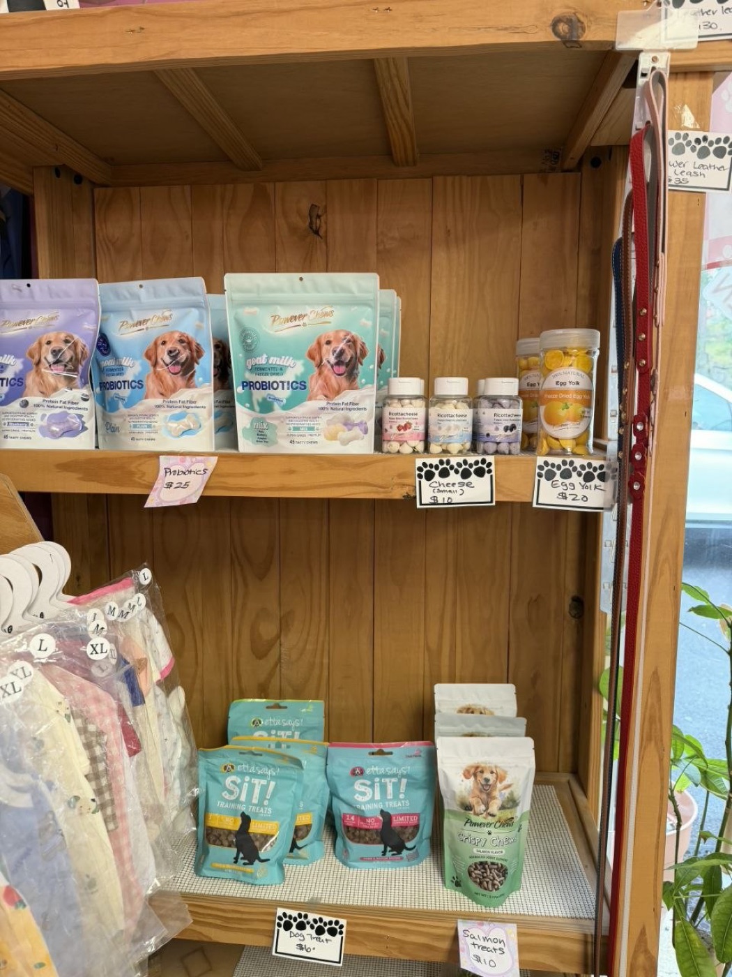 Shelves of goat milk probiotic chews, freeze-dried cheese and egg yolk jars, Sit! training treats and crispy salmon chews